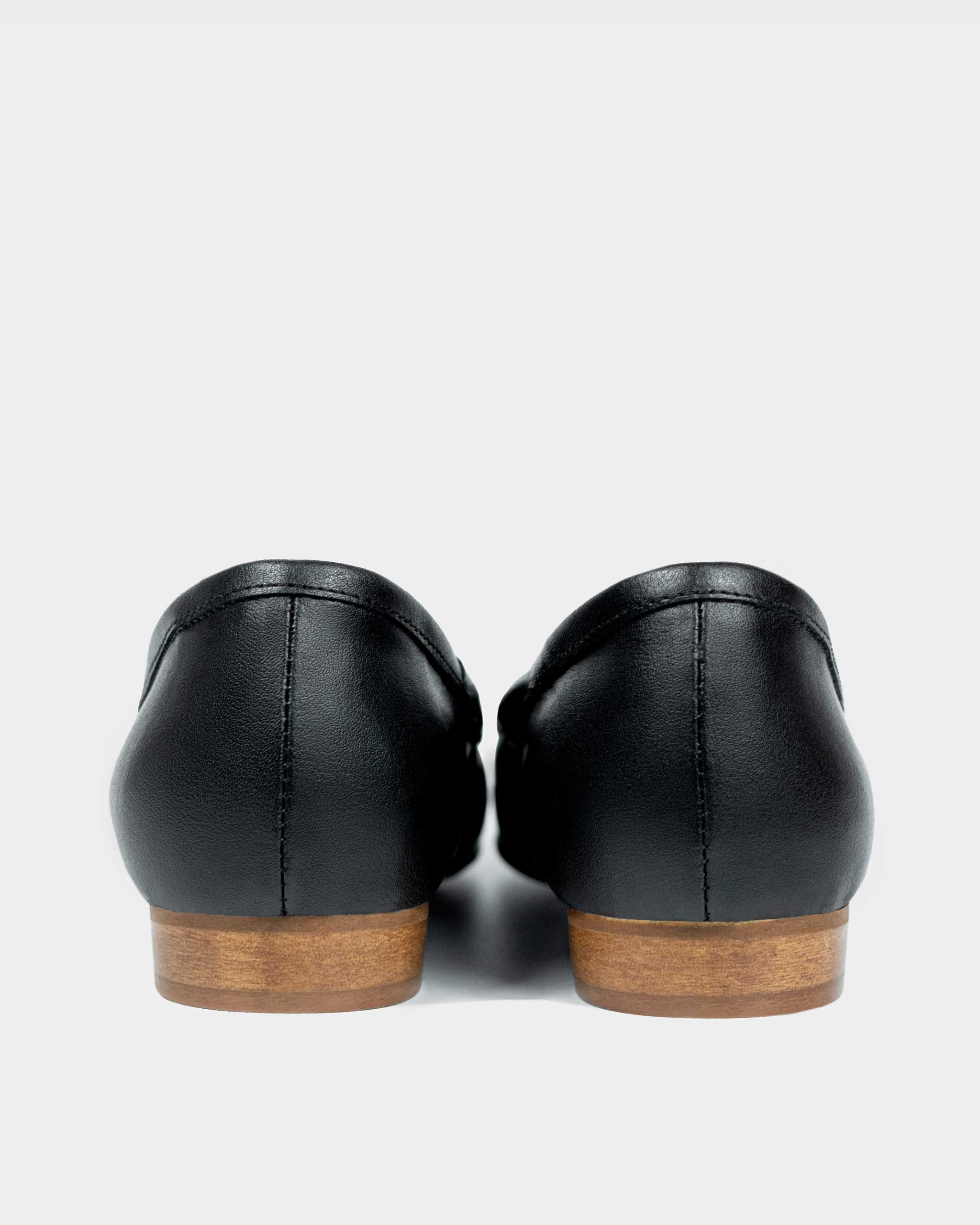 Back view of black vegan leather ballet flats with wooden soles on a white background