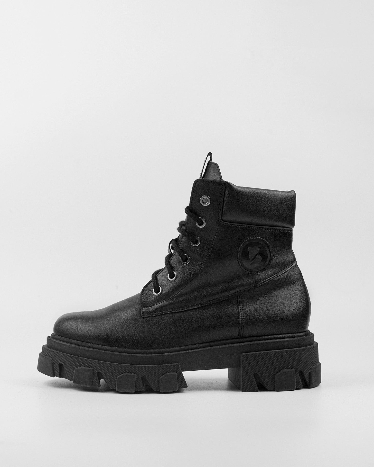 A black Riot Boots women's vegan worker boot with a chunky plant sole, featuring a lace-up closure and a high heel.