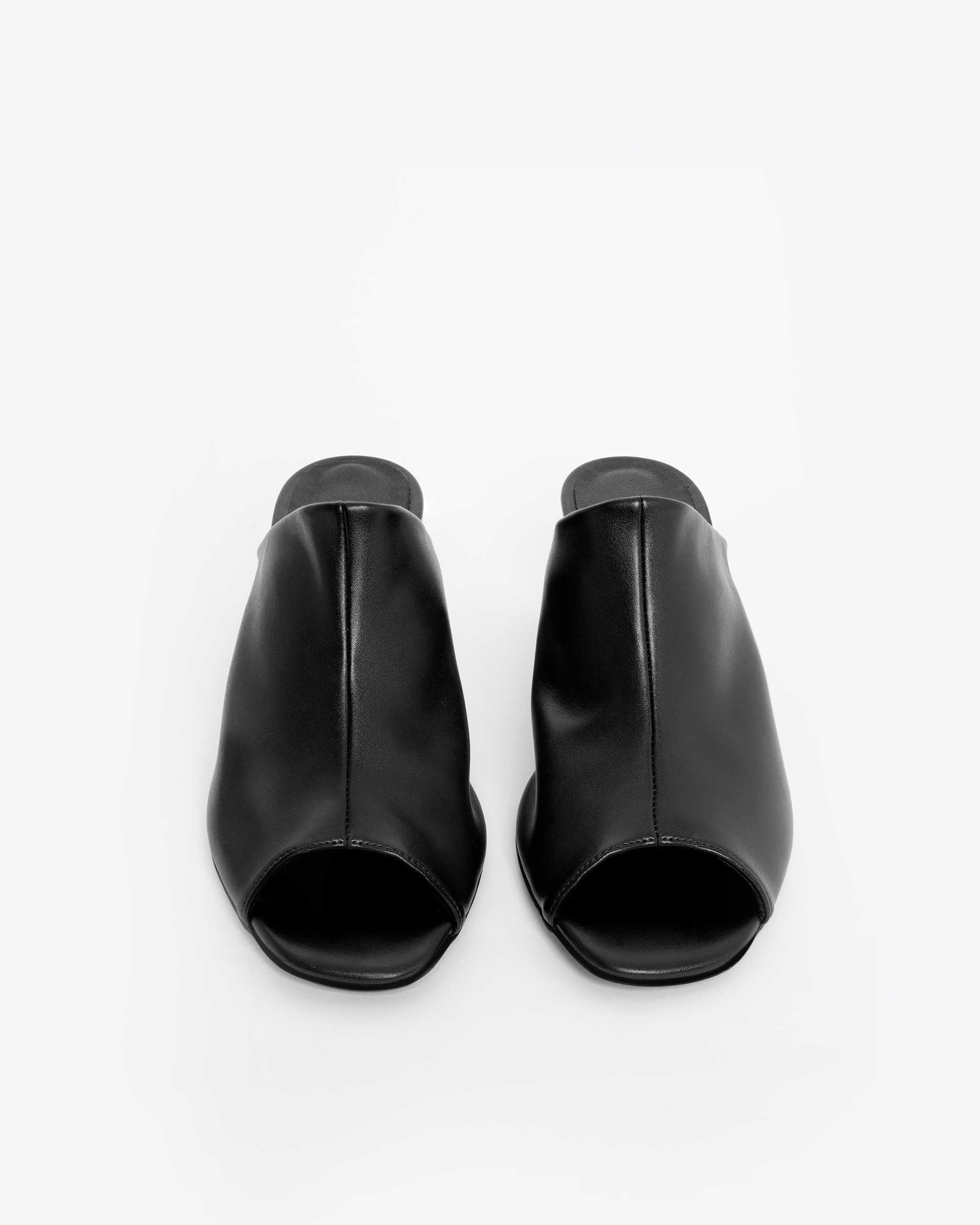 Pair of black open-toe mules with a minimalist design on a white background